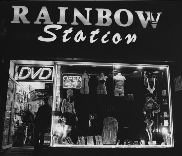 The illuminated Rainbow Station storefront at night